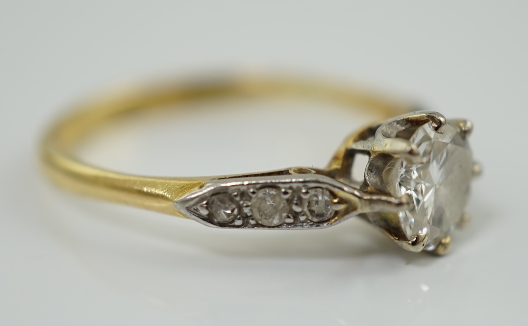 A modern 18ct gold and single stone diamond set ring, with six stone diamond chip set shoulders